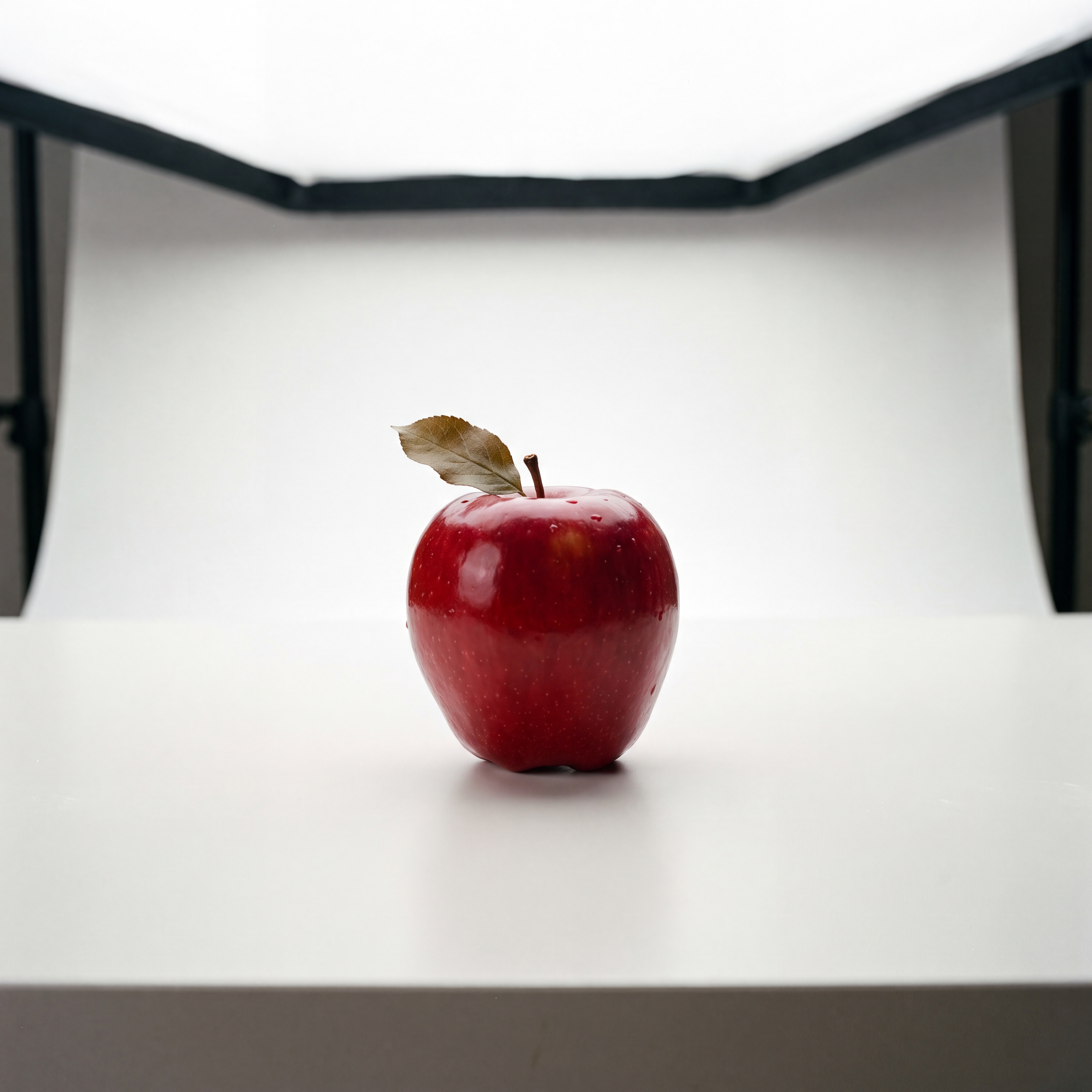 a red apple on a white table, studio lighting